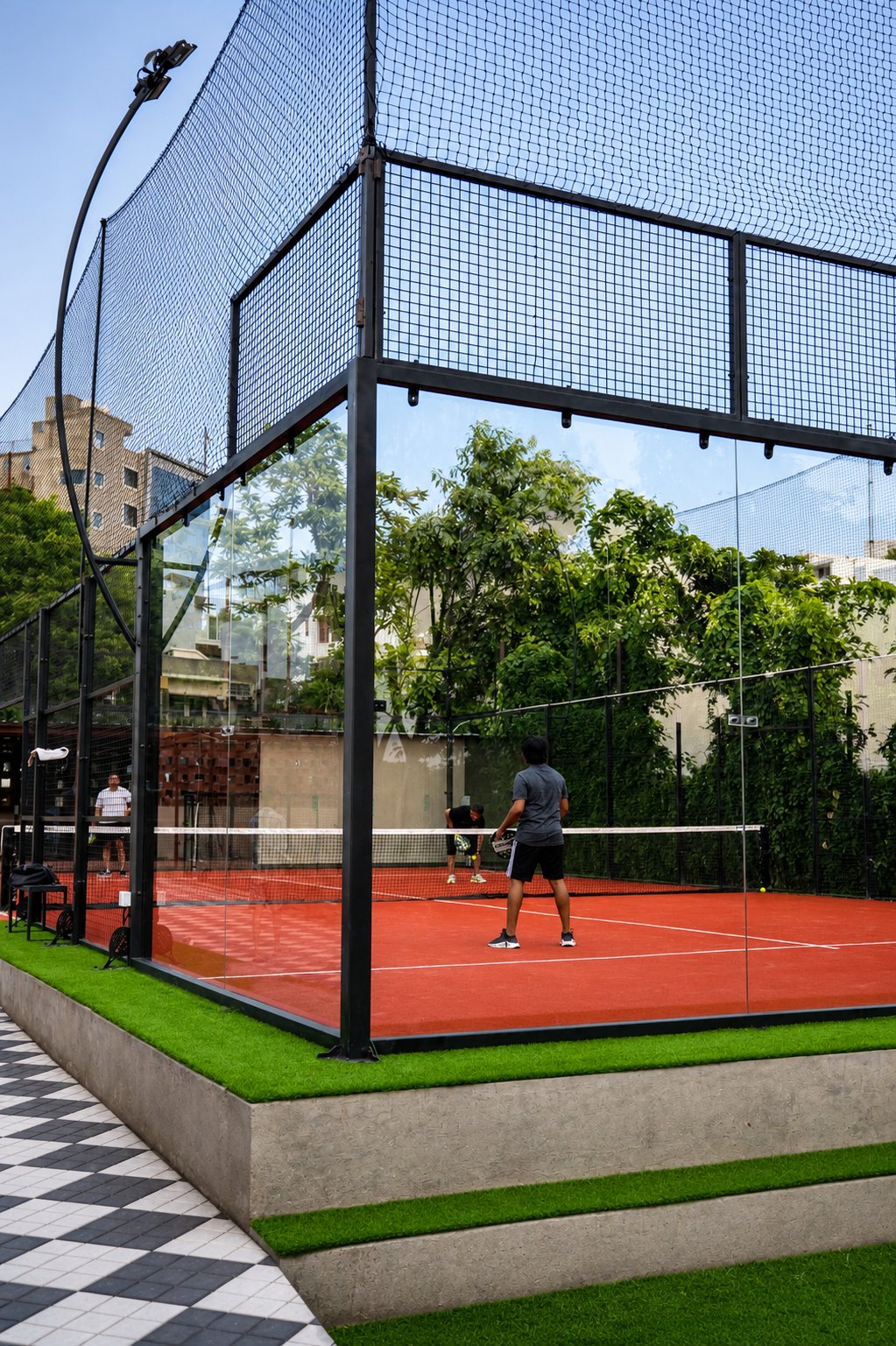 A padel match in play seen through the glass walls at Padel Fort, Jaipur